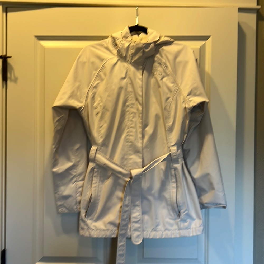 Cream colored The North Face rain jacket.
